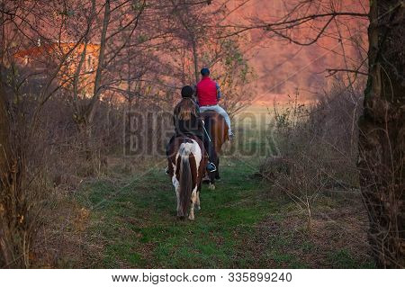 Two People On Horses Riding In The Beautiful Nature