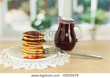 หวาน pancakes บนแผ่นกับแยมบนโต๊ะในห้องครัว