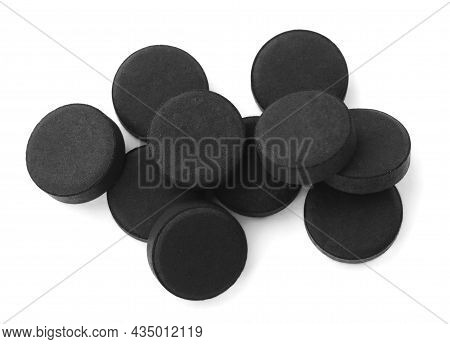 Activated Charcoal Pills On White Background, Top View. Potent Sorbent