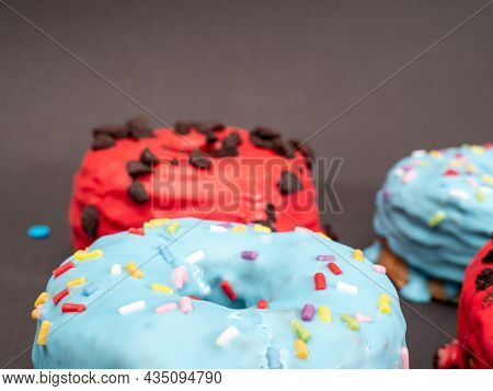 Red And Blue Cronuts On A Black Background. High Quality Photo