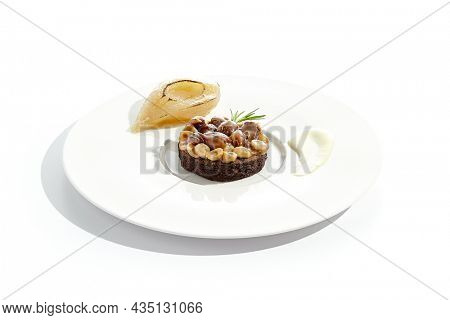 Chocolate tartlet with nuts toffee on white plate. Delicious dessert - Caramel nut tart with pear. Traditional pastry - Butterscotch tartlet with hazelnut, almond and pecan. Autumn dessert
