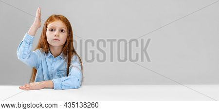 Cropped Portrait Of Deligent, Smart Pupil, Girl Raising Hand To Answer Over Gray Background