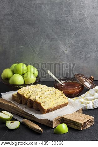 Sliced Apple And Coconut Oaf Cake On Wooden Cutting Board On Dark Background. Copy Space