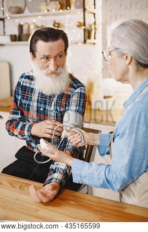 Senior Woman And Man At Home Meassure Blood Pressure