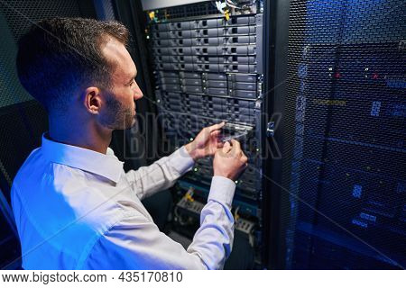 Busy Maintenance Administrator Disassembling And Repairing Computer Server In Room Indoors