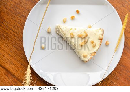 Coconut Cream Pie In The White Dish On The Wood Table That Topping With Macademia. Shooting In The S