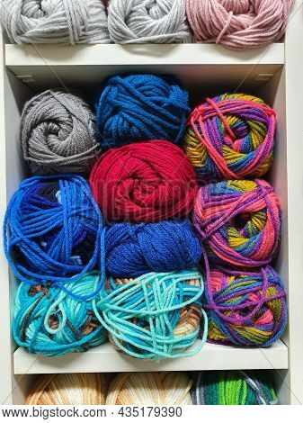 Close Up On Colorful Yarns Or Balls Of Wool For Knitting On Shelves In The Haberdashery Shop. Knitwo
