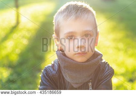 Emotive Portrait Of A Preschooler Boy. Caucasian Kid Looking In Camera Against Light Green Backgroun