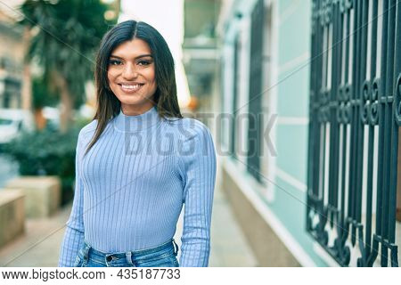 Beautiful hispanic woman smiling confient at the city