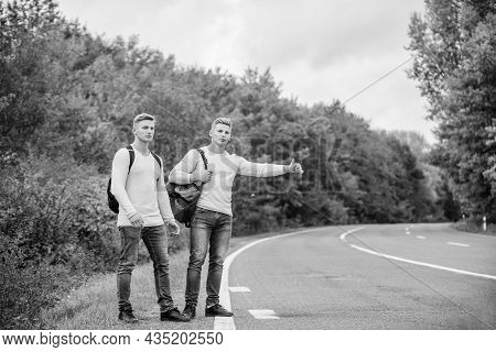 Type Of Adventure. On The Road. Enjoying Summer Hike. Looking For Transport. Twins Walking Along Roa