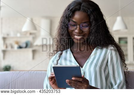 Happy Black Mixed Raced African Black Young Woman In Glasses With Perfect Smile Sitting On Sofa Hold