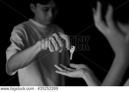A Man Handing Over A Key While Crying