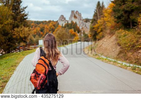 Woman Traveler With Backpack Walking Along Road To Rocks In Tustan In Autumn Carpathian Mountains. T