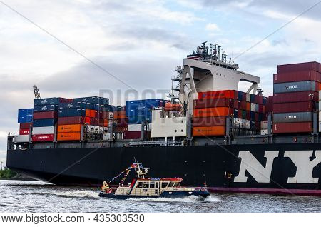 Hamburg, Germany, May 11. 2014. Small Boat And Cargo Ship With Containers Sailing On The Elbe River.