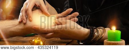 Divination By The Lines Of The Hand. A Fortune Teller Or Oracle Holds A Palm In His Hands, Predictin