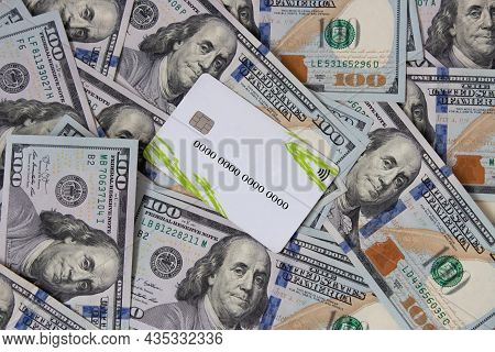 A Bunch Of Dollars And A Bank Card Close-up. The Background Is Made Of Dollars. Payment By Plastic C