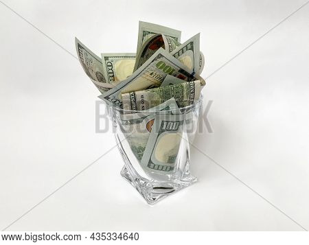 A Pile Of Dollars In A Whiskey Glass On A White Isolated Background. Retirement Savings In Dollars. 