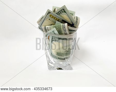 A Pile Of Dollars In A Whiskey Glass On A White Isolated Background. Retirement Savings In Dollars. 