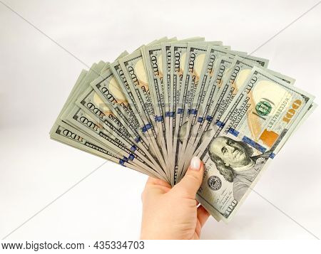 A Bunch Of Dollars In The Hands Of A Close-up. The Background Is Made Of Dollars. Isolated Dollars