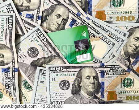 A Bunch Of Dollars And A Bank Card Close-up. The Background Is Made Of Dollars. Payment By Plastic C