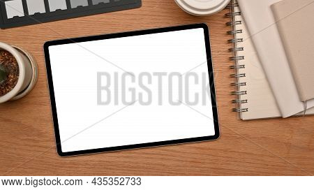 Top View Of A Modern Workspace With Tablet Mockup For Montage On Wooden Table
