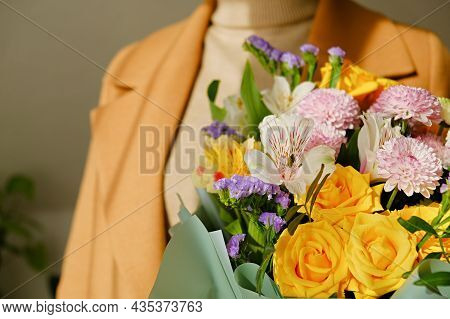 A Woman In A Beige Coat Holds A Beautiful Autumn Bouquet In Her Hands. Depersonalization Concept. Cl