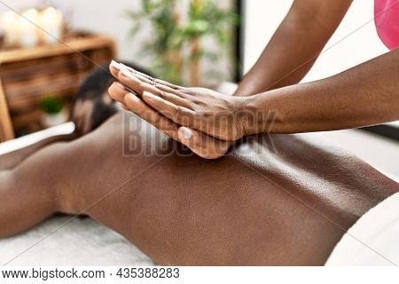 African american man reciving back massage at the clinic.