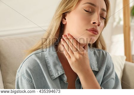 Young Woman Doing Thyroid Self Examination At Home