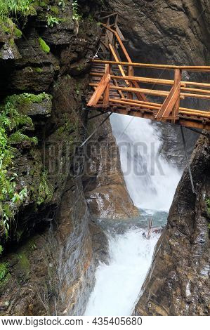 Wooden Walkpath As Bridge Over Cascading Waterfall