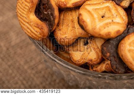 Curly Cookies Covered With Chocolate Icing In A Glass Vase, Close-up, Selective Focu