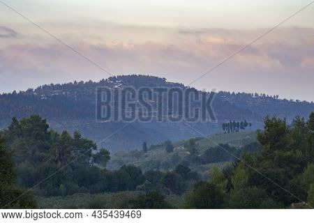 A Landscape Of The Judea Mountains, Israel, On A Hazy Dawn. Wildfire Damage Is Clearly Seen On The D