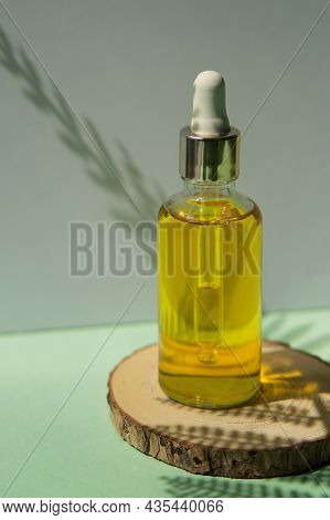 Cosmetic Bottle With Hair Oil On A Wooden Podium. The Concept Of Zero Waste And Ecology. A Hard Shad