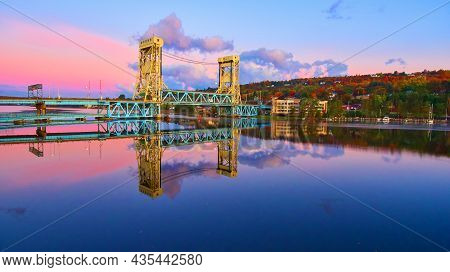 Aerial Of Lift Bridge In Houghton Over The Lake With Fall Trees And A City During Sunrise