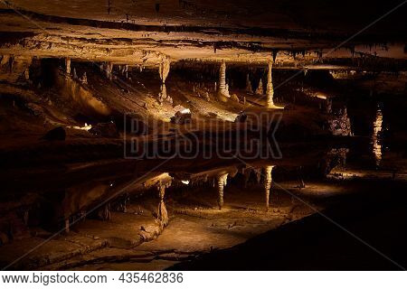Large Reflective Pond That Looks Like A Mirror In Cave With Stalagmites And Stalactites