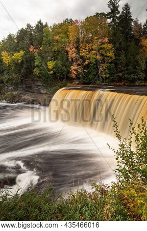 Autumn Photo Of Upper Tahquamenon Falls In Michigan With Water Cascading Into The River Below Surrou