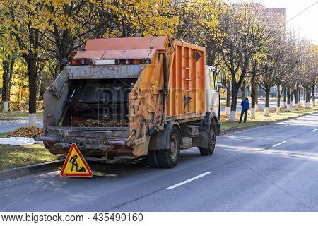 Garbage Truck Removes Autumn Fallen Leaves, Collection And Disposal Of Fallen Autumn Leaves In The C