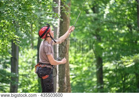 Man Belays His Partner Climber With Belaying Device And Rope. Climber's Handsman Holding Equipment F