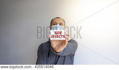 Side Effects Symbol. White Card, Words Side Effects. A Young Man In A Grey Wear And Medical Mask. Su