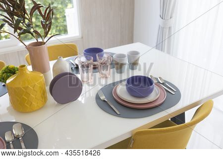 Yellow Chair And Table With Pink Pastel Plate Setting On Dinning Table.