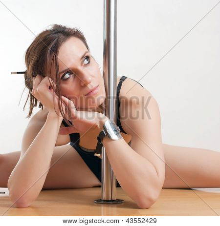 Die junge Frau in der Nähe von einer Stange