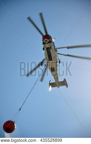 Russian KA-32 helicopter draws water from the sea to extinguish a forest fire. 30 July, 2021. Marmaris,Turkey