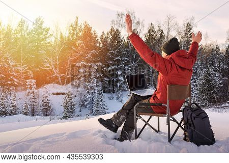 Adult Man Blogger Or Freelancer Working On A Laptop In Winter Forest. Freedom, Remote Work Concept.