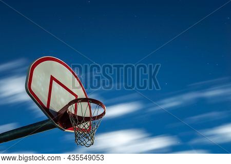 A Long Exposure Photograph Of A Dirty Orange And White Playground Basketball Hoop, Rim And Net With
