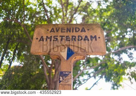 Amsterdam Avenue Sign With Blurry Tree As Background
