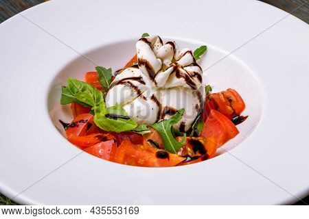 Salad With Buratta Cheese And Tomatoes On Plate