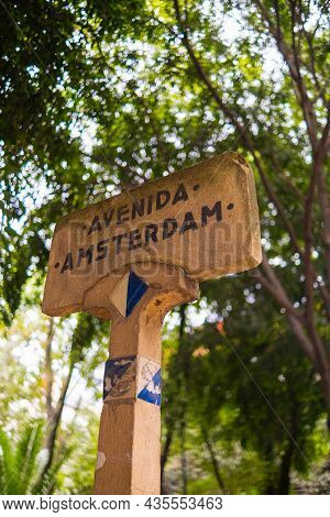 Amsterdam Avenue Sign With Blurry Tree As Background