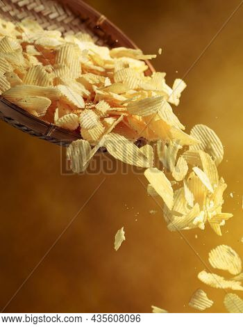 Falling Potato Chips On A Yellow Background. Copy Space.