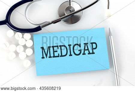 Text Medigap On A Table With Stethoscope,pills And Pen, Medical Concept.