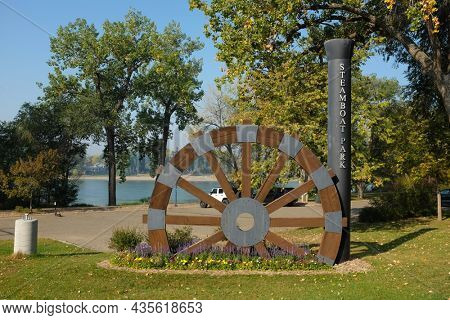 BISMARCK, NORTH DAKOTA - 3 OCT 2021: Sign at Steamboat Park along the Missouri River features trails and a replica paddlewheeler.