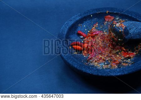 Red Chili Sauce On A Stone Mortar And Pestle. Dark Background, Focus Selected.
